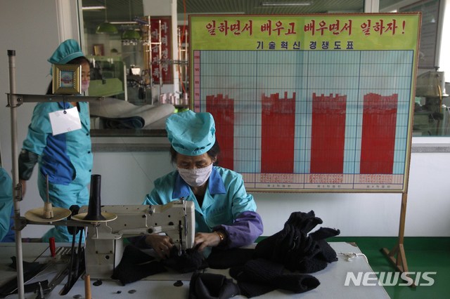 [원산=AP/뉴시스]28일 북한 강원도 원산의 원산 가죽 신발 공장에서 여성 노동자들이 기술혁신 경쟁도표를 배경으로 가죽 신발을 만들고 있다. 2020.10.30.