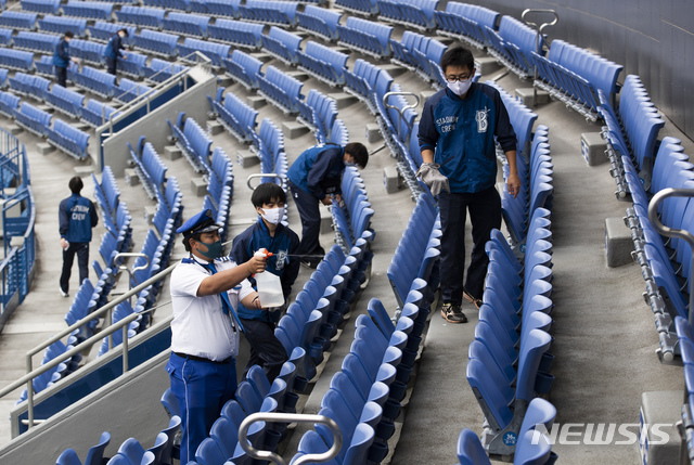 [요코하마=AP/뉴시스]30일 일본 도쿄 남쪽 요코하마의 요코하마 스타디움에서 기자단 투어가 열린 가운데 직원들이 좌석을 닦고 있다. 이번 투어는 코로나19 통제 중 경기장 관중의 움직임을 탐지하고 음식물 섭취 시 비말이 퍼지는지 여부를 기록하는 장치를 소개하기 위해 열렸다. 2020.10.30. 