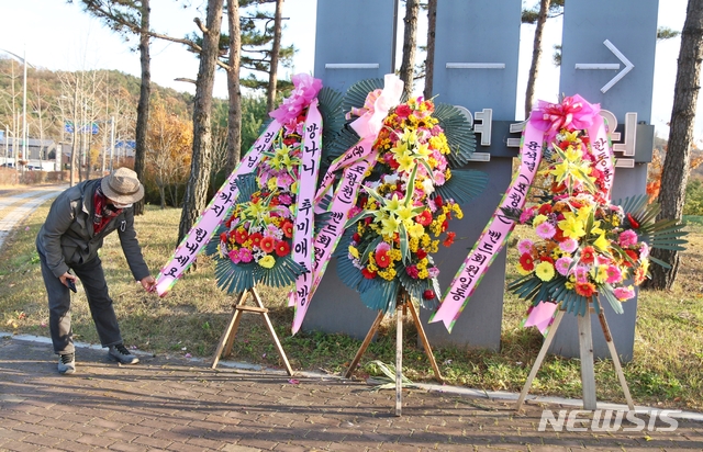 [진천=뉴시스]강신욱 기자 = 3일 오후 윤석열 검찰총장이 신임 부장검사들을 대상으로 교육하기 위해 방문하는 충북 진천군 법무연수원 입구에는 윤석열(포청천)밴드회원 일동으로 윤석열 총장과 한동훈 검사를 응원하고 추미애 법무부장관을 비난하는 화환이 놓여 있다. 한 회원이 바람에 날리는 화환을 정리하고 있다. 2020.11.03. ksw64@newsis.com 