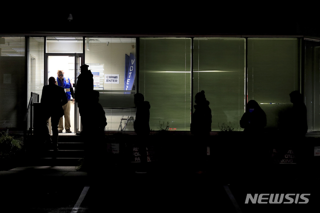 People stand in line at the Hamilton County Board of Elections as they wait to vote, Tuesday, Nov. 3, 2020, in Norwood, Ohio. (AP Photo/Aaron Doster)