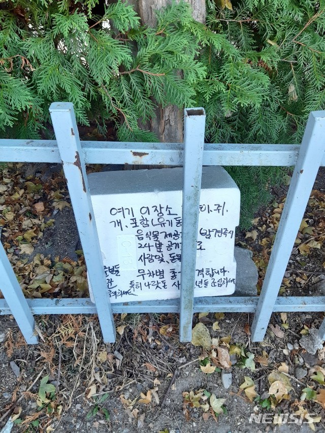 전주시 완산구 평화동 주공 2차 아파트 부근 집 없는 길고양이들에게 먹이를 주는 곳에 경고문구를 적은 박스가 놓여 있다.