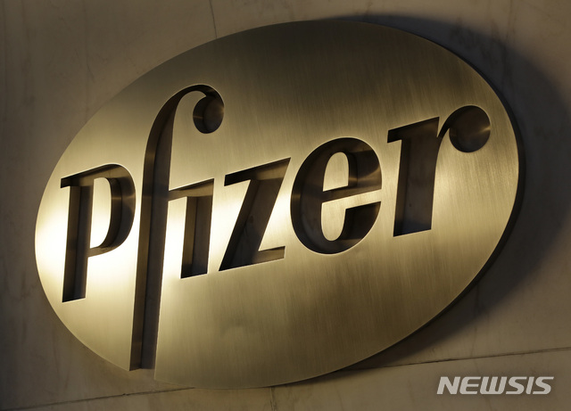 FILE - In this Monday, Nov. 23, 2015, file photo, the Pfizer logo is displayed at world headquarters in New York. On Monday, Nov. 9, 2020, Pfizer said an early peek at its vaccine data suggests the shots may be 90% effective at preventing COVID-19. (AP Photo/Mark Lennihan, File)