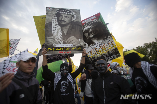 [라말라=AP/뉴시스]11일(현지시간) 요르단강 서안 도시 라말라에서 팔레스타인 전 지도자 야세르 아라파트 사망 16주기 추모 행사가 열려 팔레스타인인들이 아라파트의 사진과 팔레스타인 민족해방운동(Fatah) 깃발을 들고 있다. 2020.11.12. 