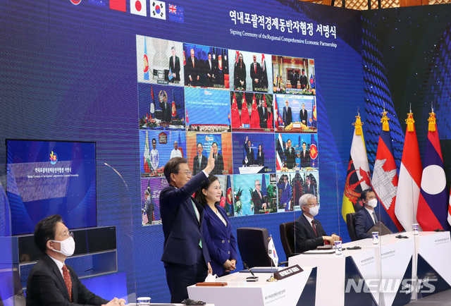 [서울=뉴시스]박영태 기자 = 문재인 대통령과 유명희 통상교섭본부장이 15일 청와대 본관에서 화상회의로 열린 역내포괄적경제동반자협정(RCEP) 정상회의 및 협정 서명식에 참석해 서명 후 기념촬영을 하며 손을 흔들고 있다. 2020.11.15. since1999@newsis.com