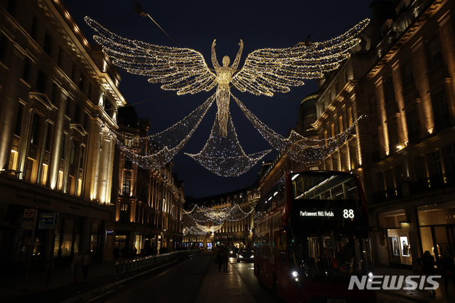 [런던=AP/뉴시스]15일(현지시간) 영국 런던의 리젠트 스트리트 상점들이  코로나19 봉쇄로 문을 닫은 가운데 '크리스마스의 정령'이라는 주제의 크리스마스 조명이 불을 밝히고 있다. 2020.11.16.  