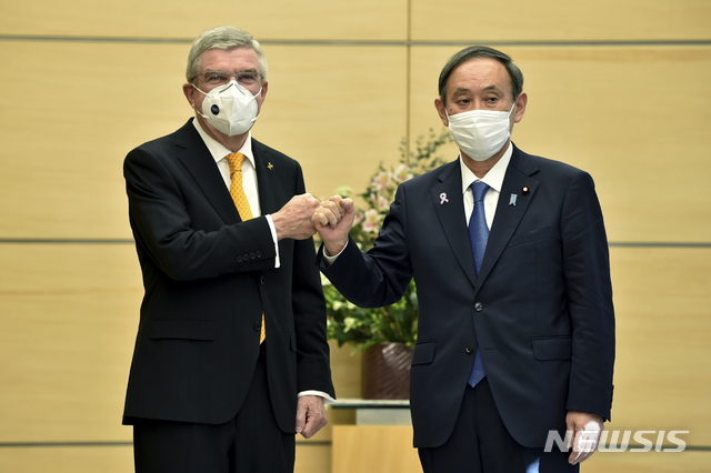 [도쿄=AP/뉴시스]일본을 방문한 토마스 바흐 국제올림픽위원회(IOC) 위원장(왼쪽)이 16일 오전 스가 요시히데 일본 총리(오른쪽)와 도쿄 총리 관저에서 만나 회담 전 주먹 인사를 나누고 있다. 2020.11.16.