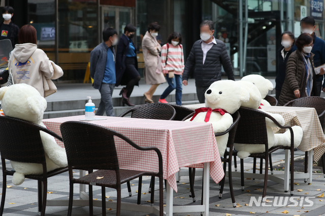 [서울=뉴시스] 고승민 기자 = 국내 코로나19 신규 확진자가 300여명에 이르는 것으로 집계된 18일 서울 무교동 일대에 다동무교동 타운매니지먼트 협의체가 설치한 사회적 거리두기 인형과 식탁이 놓여져 있다. 직장인들이 점심식사를 하러 식당으로 향하고 있다. 2020.11.18. kkssmm99@newsis.com 