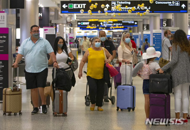[마이애미=AP/뉴시스] 22일(현지시간) 신종 코로나바이러스 감염증(코로나19)이 확산하는 가운데 미국 플로리다주의 마이애미 국제공항에서 승객들이 마스크를 착용한 채 걷고 있다. 2020.11.23. 