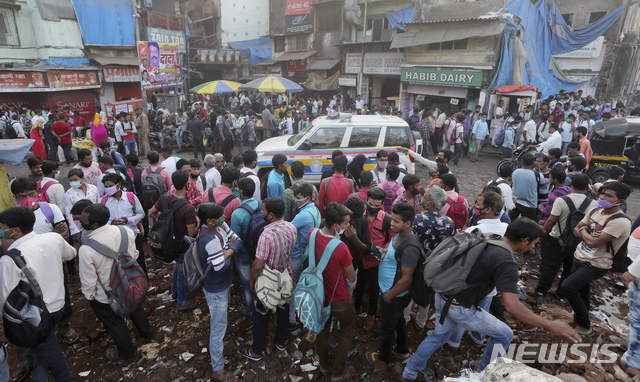 [뭄바이=AP/뉴시스]23일(현지시간) 인도 뭄바이에서 이주 노동자들이 일거리를 찾고 있는 동안 순찰차 한 대가 거리를 순찰하고 있다. 2020.11.23.