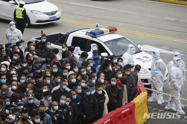 [상하이=AP/뉴시스]23일 중국 상하이 푸둥 국제공항에서 마스크를 쓴 노동자들이 코로나19 검사를 받기 위해 모여드는 가운데 보호복을 입은 보안요원들이 대기하고 있다. 2020.11.23.