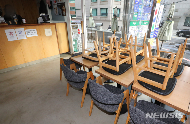 [서울=뉴시스]배훈식 기자 = 수도권 사회적 거리두기 2단계가 시행된 지난 24일 오후 서울 서초구의 한 카페에 의자들이 테이블 위로 올라가 있다. 2단계 방역조치가 시행되면 카페는 포장과 배달만 허용되고 음식점은 21시 이후 포장, 배달만 가능하다. 2020.11.27. dahora83@newsis.com