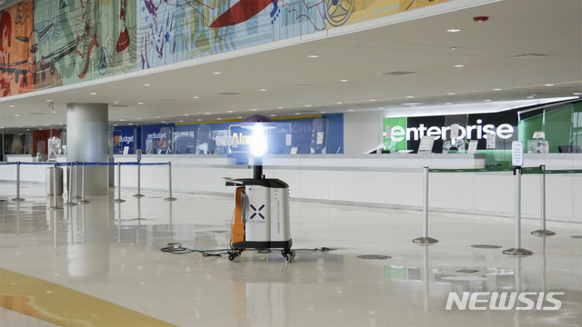  [샌안토니오( 미 텍사스주)= AP/뉴시스]미국 텍사스 샌안토니오 공항 로비에 설치된 코로나19 대비 자외선 소독 로봇이 보이고 있다. 2021.04.16.