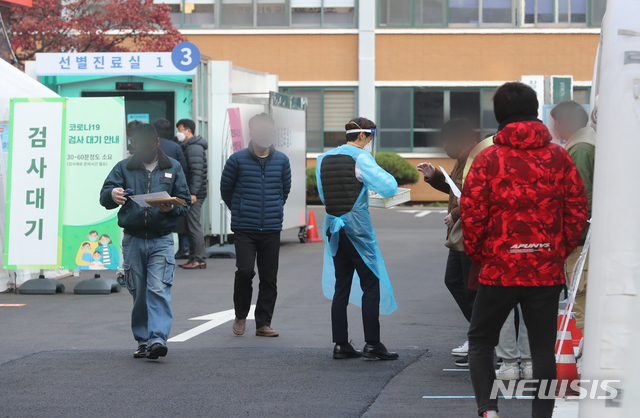 [서울=뉴시스]배훈식 기자 = 수도권 사회적 거리두기 2단계 시행에도 신종 코로나바이러스 감염증(코로나19) 확진자 수가 300명대를 기록한 25일 오전 서울 중구 국립중앙의료원 선별진료소에서 코로나19 검사를 받은 시민들이 영수증을 받고 있다. 2020.11.25.  dahora83@newsis.com