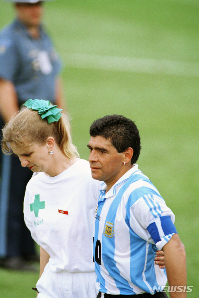 [부에노스아이레스=AP/뉴시스]아르헨티나 축구 영웅 디에고 마라도나가 25일(현지시간) 부에노스아이레스 자택에서 심장마비로 타계했다. 향년 60세. 마라도나는 이달 초 만성 경막하혈종 진단을 받아 뇌수술을 받고 퇴원한 지 2주 만에 숨졌다. 사진은 1994년 6월 25일 마라도나가 미 매사추세츠주 폭스버러에서 나이지리아를 2-1로 물리친 후 약물 검사를 받기 위해 국제축구연맹(FIFA) 의료 관계자와 함께 경기장을 나서는 모습. 2020.11.26.