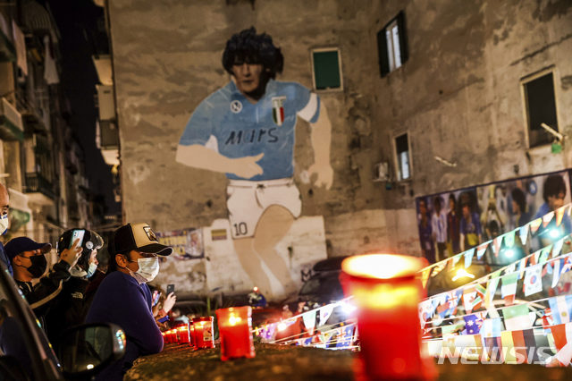 [나폴리=AP/뉴시스]25일(현지시간) 이탈리아 나폴리에 있는 축구 전설 디에고 마라도나의 벽화 아래 사람들이 모여 촛불을 밝히며 그의 죽음을 애도하고 있다. 1986년 아르헨티나를 월드컵 우승으로 이끈 아르헨티나 축구 영웅 디에고 마라도나가 25일 아르헨티나 부에노스아이레스 자택에서 심장마비로 타계했다. 향년 60세. 2020.11.26. 