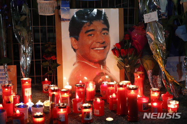 [나폴리( 이탈리아)= AP/뉴시스] 나폴리의 상파울루 축구경기장 앞에 설치된  마라도나의 추모의 장소에 26일 그의 사진과 수많은 촛불이 놓여져있다.   