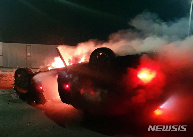 [부산=뉴시스] 전복 사고 이후 화재 발생한 승용차. (사진=부산경찰청 제공)
