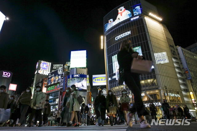 [도쿄=AP/뉴시스]지난 1일 일본 도쿄의 밤 거리를 신종 코로나바이러스 감염증(코로나19)을 예방하기 위해 마스크를 착용한 시민들이 걷고 있다. 도쿄에서는 주류를 제공하는 음식점의 영업시간이 오후 10시로 단축된 상태다. 2020.12.02.