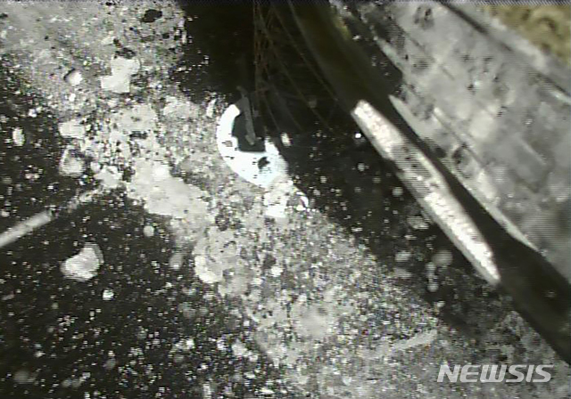 [AP/뉴시스] 일본 소행성 탐사선 '하야부사2'가 2019년 소행성 '류구'의 지표면 표본을 채취하는 장면. 일본 우주항공연구개발기구(JAXA)는 5일 지구에 접근한 소행성 탐사선 '하야부사2'가 소행성 '류구'에서 채취한 물질이 담긴 캡슐을 분리하는 데 성공했다고 발표했다. 캡슐은 6일 오전 호주 서부의 사막에 착륙할 예정이다. 2020.12.5.