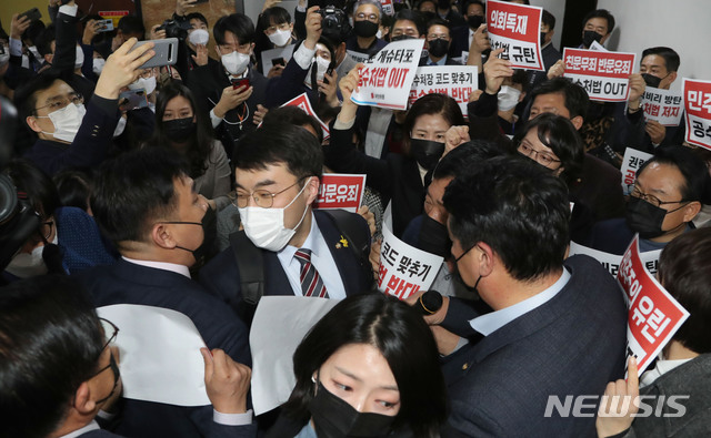 [서울=뉴시스] 최동준 기자 = 7일 오후 국민의힘 의원들이 더불어민주당의 고위공직자범죄수사처(공수처)법 개정안 등 입법 강행에 맞서 서울 국회 법사위 회의실 앞에 집결해 규탄 구호를 외치는 가운데 더불어민주당 김남국 의원이 국민의힘 의원들 사이를 뚫고 회의장으로 들어가고 있다. (공동취재사진) 2020.12.07. photo@newsis.com