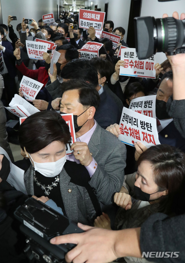 [서울=뉴시스] 최동준 기자 = 7일 오후 국민의힘 의원들이 더불어민주당의 고위공직자범죄수사처(공수처)법 개정안 등 입법 강행에 맞서 국회 법사위 회의실 앞에 집결해 규탄 구호를 외치는 가운데 더불어민주당 백혜련 법안심사1소위원장이 국민의힘 의원들 사이를 뚫고 회의장으로 들어가고 있다. (공동취재사진) 2020.12.07. photo@newsis.com