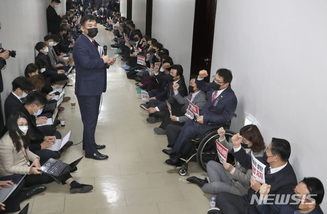 [서울=뉴시스] 전진환 기자 = 더불어민주당의 공수처법 개정안 강행처리에 항의하는 국민의힘 의원들이 7일 오후 회의가 열리는 국회 법제사법위원회 회의실 앞에 연좌해 구호를 외치고 있다. (공동취재사진) 2020.12.07. photo@newsis.com