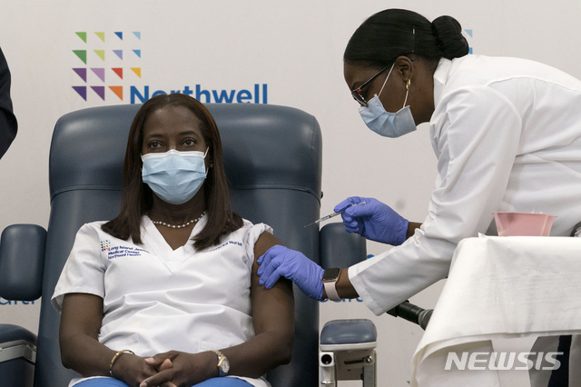 [퀸스=AP/뉴시스]지난 12월14일 뉴욕 퀸스에서 일하는 중환자실 간호사 샌드라 린지가 미국 최초로 신종 코로나바이러스 감염증(코로나19) 백신을 맞고 있다. 2020.12.29.