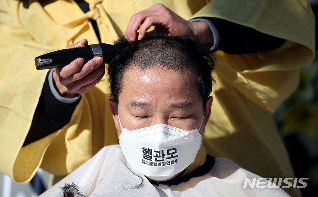 [서울=뉴시스] 김진아 기자 = 대한피트니스경영자협회와 헬스클럽관장연합회 관계자들이 16일 서울 여의도 국회 앞에서 열린 코로나19로 인한 체육시설 집합금지조치 관련 기자회견에서 생존권 보장을 촉구하며 삭발식을 하고 있다. 2020.12.16. bluesoda@newsis.com