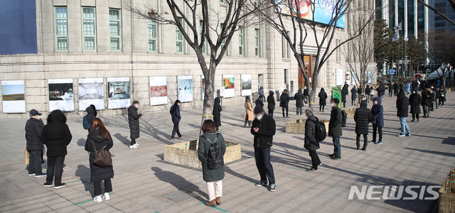 [서울=뉴시스]김선웅 기자 = 1062명의 신규 코로나19 확진자가 발생한 지난 18일 서울광장에 설치된 중구 임시 선별검사소에서 시민들이 코로나19 검사를 받기 위해 줄을 서고 있다. 2020.12.18. mangusta@newsis.com