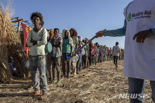 [카다리프(수단)=AP/뉴시스]지난 12일 수단 카다리프의 움 라쿠바 난민수용소에서 에티오피아 티그라이 난민들이 음식을 배급받기 위해 길게 줄지어 서서 기다리고 있다. 에티오피아 서부 지역에서 최근 100명 이상이 숨지는 종족 학살이 벌어졌다고 에티오피아 인권위원회가 23일(현지시간) 발표했다. 위원회는 사망자 수가 앞으로 더 늘어날 것으로 우려된다고 덧붙였다. 2020.12.24