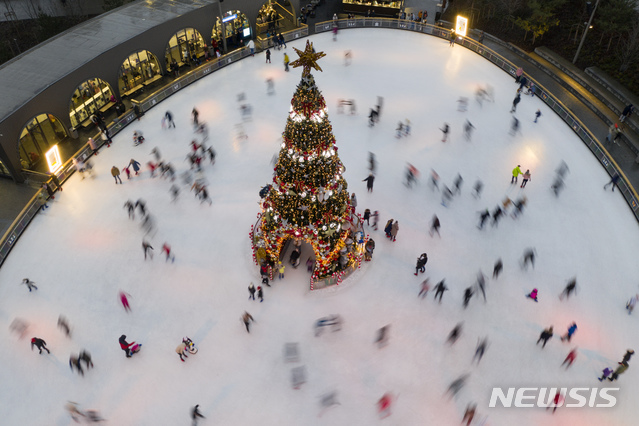 [키이우=AP/뉴시스] 지난 2020년 12월21일(현지시간) 우크라이나 수도 키이우의 한 빙상장에서 시민들이 조명이 반짝이는 크리스마스 트리를 중심으로 스케이트를 즐기고 있다. 올해는 전쟁과 전력난으로 조명이 꺼진 트리를 설치하기로 했다. 2022.11.29.