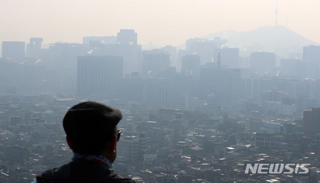 [서울=뉴시스] 이영환 기자 = 지난 22일 오전 서울 종로구 인왕산 자락에서 한 시민이 초미세먼지와 연무의 영향으로 뿌연 도심을 바라보고 있다. 2020.12.22. 20hwan@newsis.com