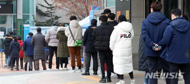 [서울=뉴시스] 이영환 기자 = 신종 코로나바이러스 감염증(코로나19) 신규 확진자가 사흘만에 1000명대로 올라선 23일 오후 서울 성동구청 농구장에 마련된 코로나19 임시선별검사소에서 시민들이 검사를 받기 위해 대기하고 있다. 2020.12.23. 20hwan@newsis.com