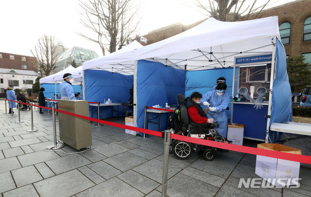 [서울=뉴시스]최진석 기자 = 24일 서울 종로구 동숭동 마로니에공원에 차려진 찾아가는 선별진료소에서 한국장애인자립생활센터협의회 회원들과 보조자들이 코로나19 검사를 받고 있다. 2020.12.24. myjs@newsis.com