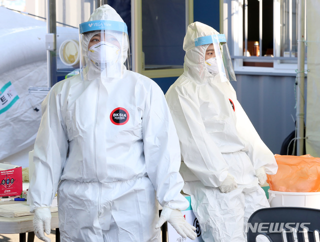 [서울=뉴시스] 이영환 기자 = 크리스마스인 25일 오후 서울 중구 서울역광장에 마련된 임시선별검사소에서 의료진이 잠시 휴식을 취하고 있다. 중앙방역대책본부는 25일 0시 기준 신규 신종 코로나바이러스 감염증(코로나19) 확진자가 1241명으로 조사됐다고 밝혔다. 2020.12.25. 20hwan@newsis.com 