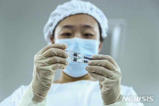 [베이징=AP/뉴시스]중국 시노팜 베이징 공장에서 직원이 코로나19 백신을 살펴보고 있다. 2020.12.31.