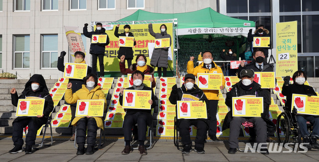 [서울=뉴시스] 전진환 기자 = 1일 오전 서울 여의도 국회 본관 앞 단식농성장에서 열린 정의당 신년인사회에서 김종철 대표 등 참석자들이 중대재해기업처벌법 제정 촉구 구호를 외치고 있다. (공동취재사진) 2021.01.01. photo@newsis.com