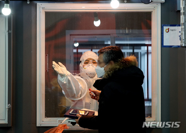 [서울=뉴시스] 김병문 기자 = 새해 첫날인 1일 오후 서울 용산구 서울역 임시선별진료소에서 의료진이 업무를 보고 있다. 2021.01.01. dadazon@newsis.com