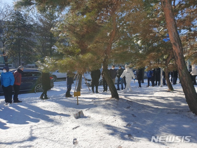 [수원=뉴시스] 이병희 기자 = 한파경보가 발효된 8일 오전 10시30분께 경기 수원시 권선구보건소 임시선별검사소에서 근무자가 눈밭에서 기다리는 시민들에게 안내사항을 전달하고 있다. 2020.01.08. iambh@newsis.com