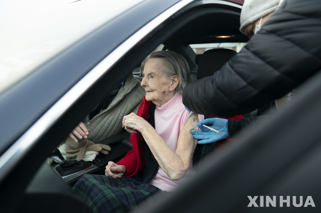 [그레이터맨체스터=신화/뉴시스]7일(현지시간) 영국 그레이터 맨체스터의 하이드 레저 센터에 마련된 드라이브스루 백신 접종소에서 올해 99세 된 한 할머니가 차에 앉아 화이자 백신 2회차 접종을 하고 있다. 2021.01.08.