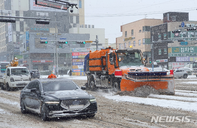 [제주=뉴시스]우장호 기자 = 북극발 한파가 사흘째 기승을 부리고 있는 8일 오전 제주시 이도2동 구세무서 사거리 인근 도로에서 제설차가 부지런히 쌓인 눈을 치우고 있다. 2021.01.08. woo1223@newsis.com