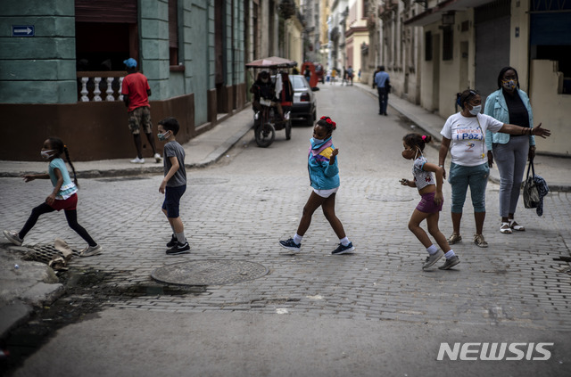 [아바나=AP/뉴시스] 1월11일(현지시간) 쿠바 수도 아바나에서 코로나19 예방을 위해 마스크를 쓴 어린이들이 거리를 건너고 있다. 쿠바보건부는 어린이 감염이 지난 11개월간 2882명이었고, 점점 늘어나는 추세라고 2월1일 발표했다. 