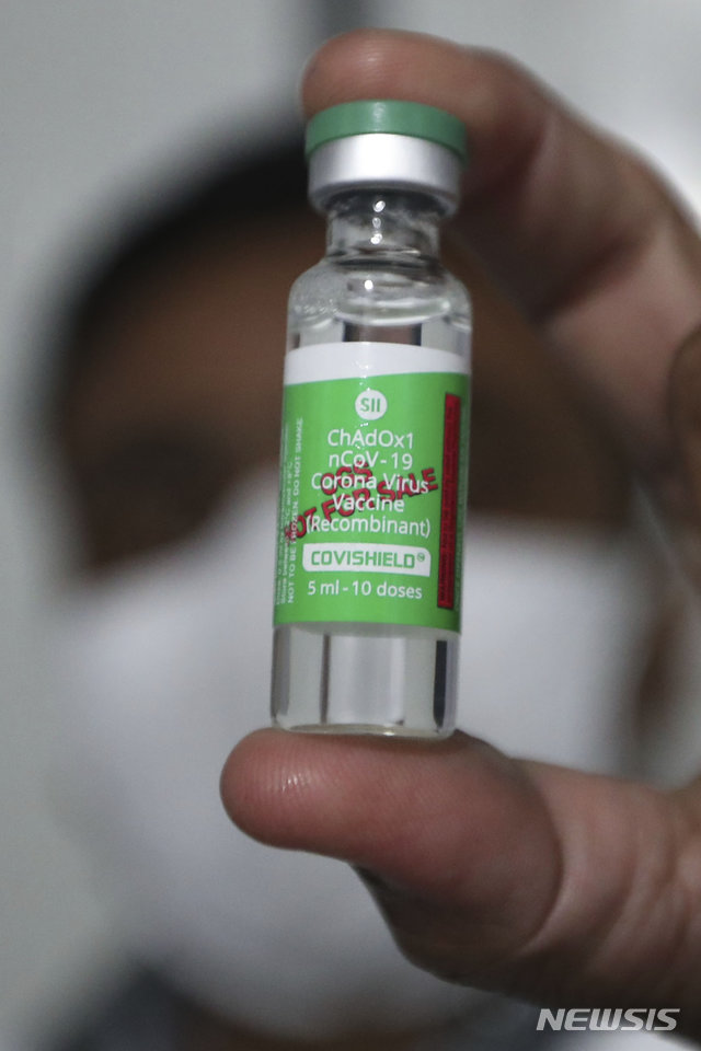 [아마다바드=AP/뉴시스]지난 1월12일(현지시간) 인도 구자라트주 아마다바드 시립병원 내 냉장보관소에서 한 의료인이 옥스포드대와 아스트라제네카가 공동개발하고 인도가 생산한 코비실드(Covishield) 백신을 보이고 있다. 2021.11.30.