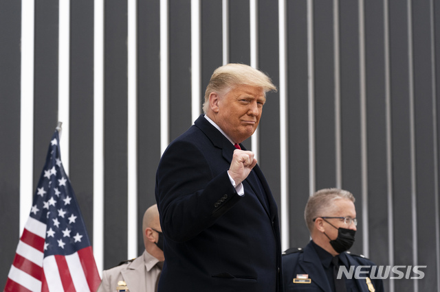 [앨러모=AP/뉴시스]지난달 12일(현지시간) 도널드 트럼프 당시 미국 대통령이 텍사스 앨러모 국경 장벽 앞에서 주먹을 들어보이고 있다. 2021.02.28.