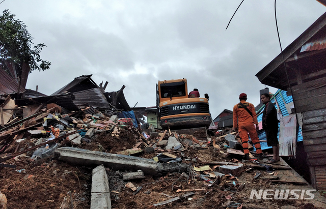 [마무주(인도네시아)=AP/뉴시스] 15일(현지시간) 인도네시아 술라웨시섬 마무주의 지진 피해 현장에서 구조대가 실종자 수색 작업을 벌이고 있다. 2021.01.15
