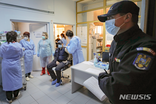 [AP/뉴시스] 15일 동유럽 루마니아 부카레스트 병원에서 경찰관이 코로나 19 백신 접종주사 순서를 기다리고 있다