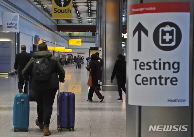 [런던=AP/뉴시스]영국 런던 히스로 공항의 코로나19 검사소 앞을 여행객들이 지나고 있다. 2021.2.2.