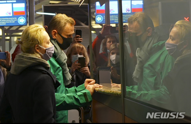 [모스크바=AP/뉴시스] 블라디미르 푸틴 러시아 대통령의 정적인 야권 지도자 알렉세이 나발니와 그의 아내가 17일(현지시간) 러시아 셰레메티예보 공항에서 입국심사를 받고 있다. 나발니는 이날 독일 베를린에서 떠나 러시아에 도착했다. 러시아 당국은 그가 공항에 도착하자마자 바로 체포했다. 2021.01.18 