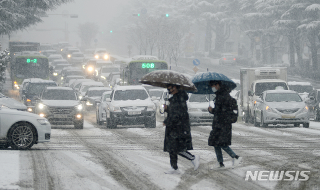 [전주=뉴시스] 김얼 기자 = 전북지역에 대설주의보가 발효된 18일 전주시 덕진구 백제대로에서 시민들이 눈을 피해 서두르며 발걸음을 옮기고 있다. 2021.01.18.pmkeul@newsis.com