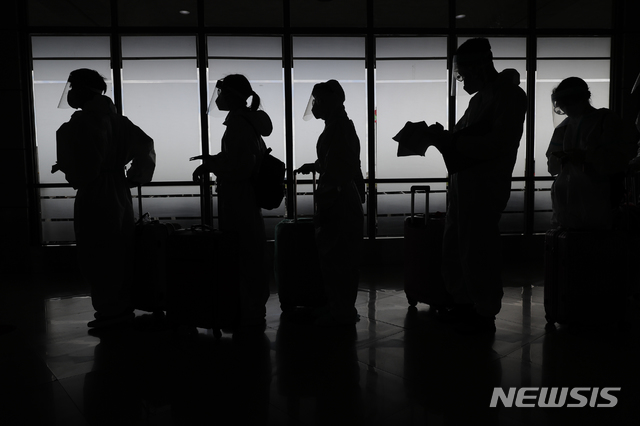 [마닐라=AP/뉴시스]18일 필리핀 마닐라 국제공항에서 코로나19 예방을 위해 보호복을 입은 외국인 승객들이 중국 행 비행기 탑승 준비를 하고 있다. 2021.01.18.